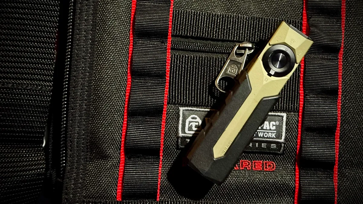 Olight ArkPro Ultra in olive green and black, clipped to the MOLLE webbing of a Veto Pro Pac tool bag
