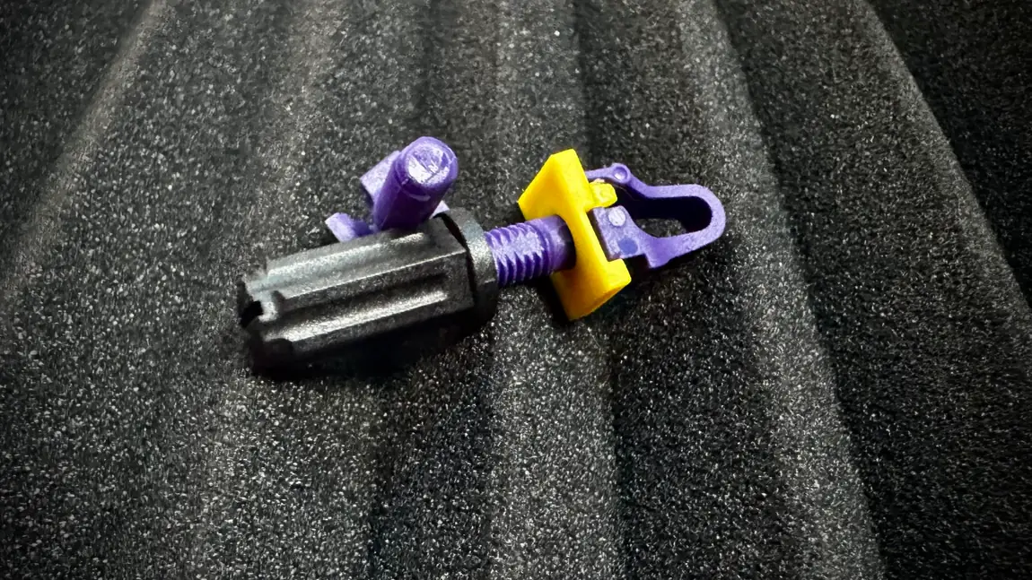 A Rackstuds Series II 3.2 Purple stud assembled on foam, the purple front-hook stud and threaded post through a yellow washer and black lock nut, the variant for thicker rails